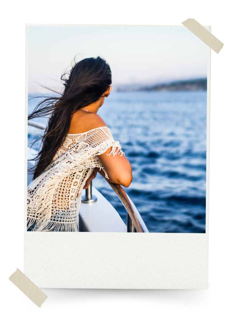 A woman on a boat enjoying her vacation, looking out over the water.