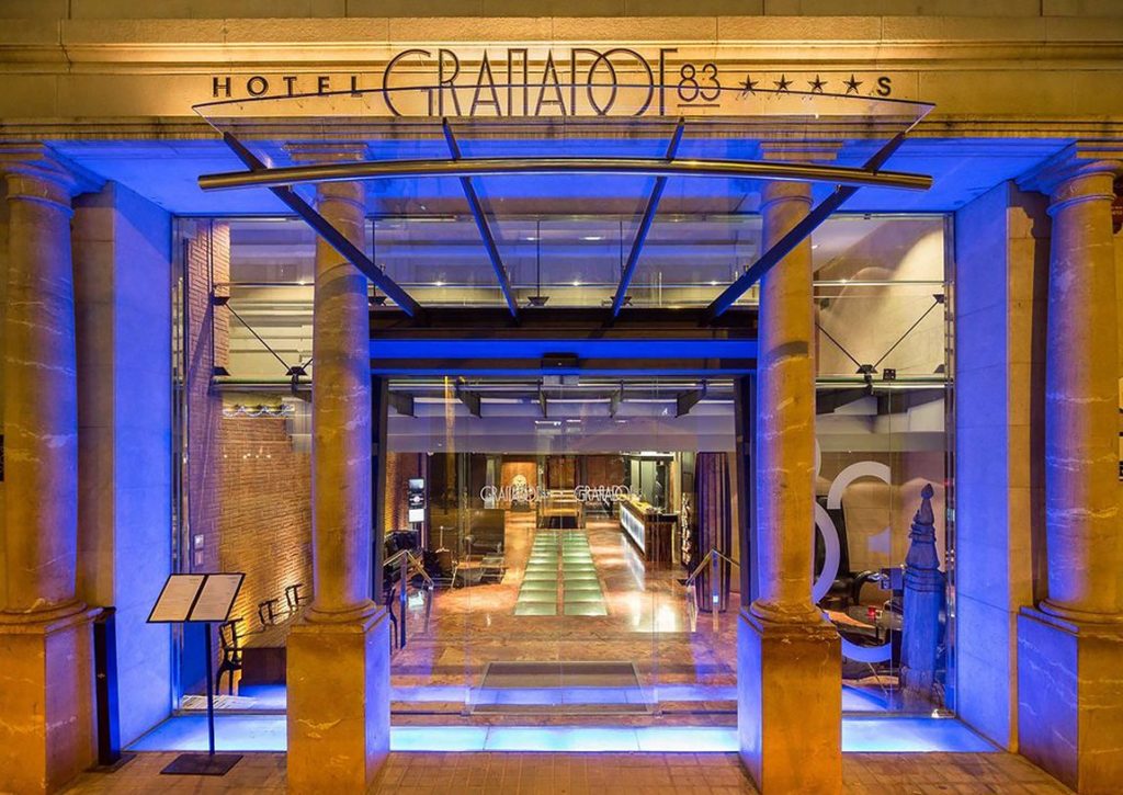 The entrance to a hotel is lit up with blue lights.